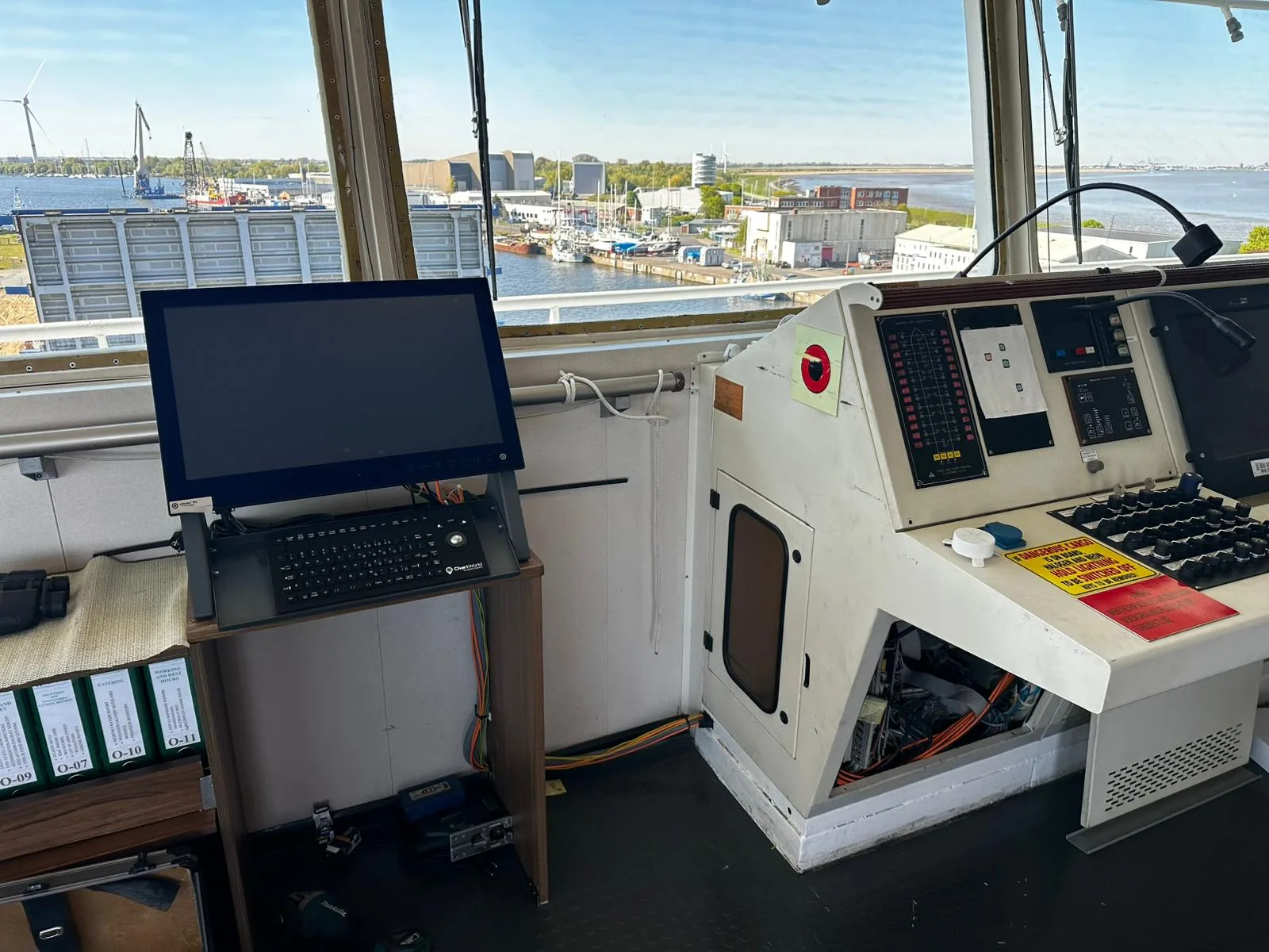 Newly installed ECDIS display with keyboard and trackball next to the bridge console of a cargo vessel