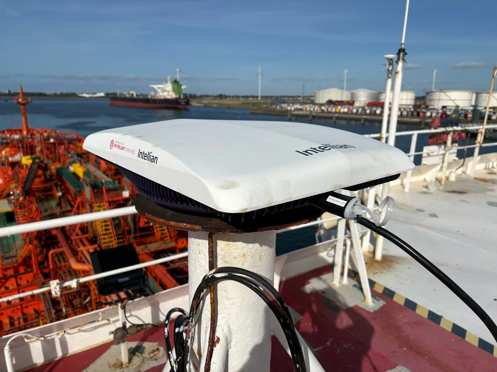 Intellian OW10 OneWeb antenna on its mast with the Port of Rotterdam in the background